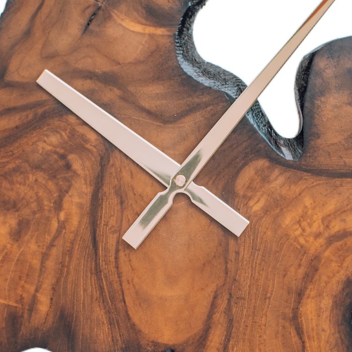 Swirling burl grain on a teak wall clock face with steel hands